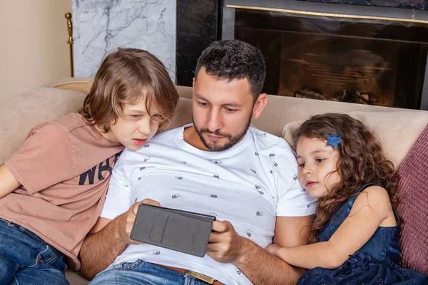 Papa avec des enfants regardant des vidéos sur un smartphone — Photo