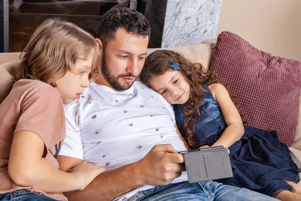 Çocuklu baba akıllı telefondan video izliyor. — Stok fotoğraf