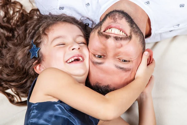 Pai e filha deitam-se na cama cabeça a cabeça — Fotografia de Stock