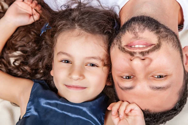 Vater und Tochter liegen Kopf an Kopf auf dem Bett — Stockfoto