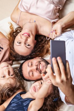Mutlu aile akıllı telefonuyla selfie çekiyor.
