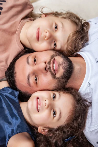 Father lies in the middle between his children — Stock Photo, Image