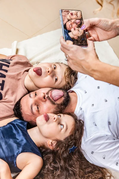 Мама фотографує сім'ю на смартфоні. — стокове фото