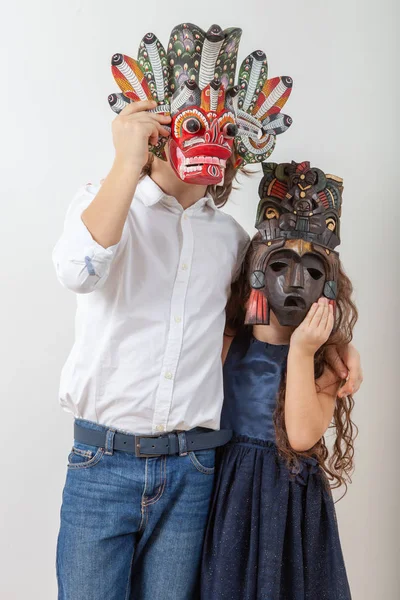 Dziewczyna i chłopiec w drewnianych indiańskich maskach — Zdjęcie stockowe
