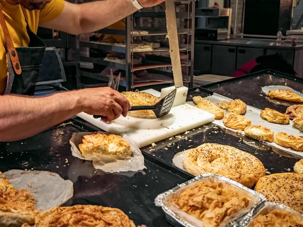 Baker cuts pastries into batch pieces for sale