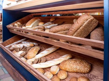 Pazar tezgahında bir yığın taze çörek ve ekmek.