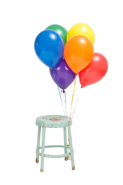 Шесть гелиевых шаров, привязанных к стулу — стоковое фото