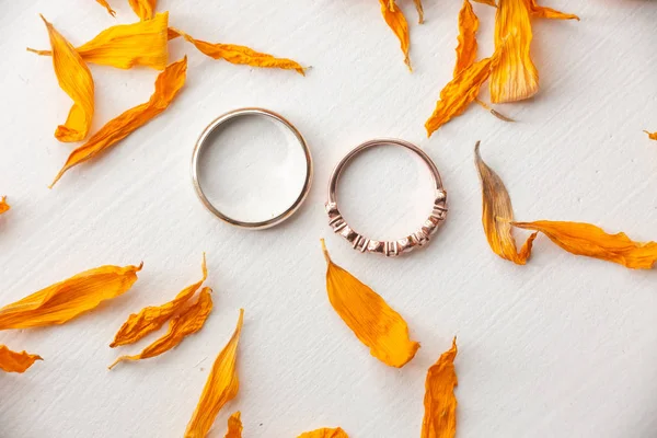 Wedding rings with orange dried flower petals — 스톡 사진