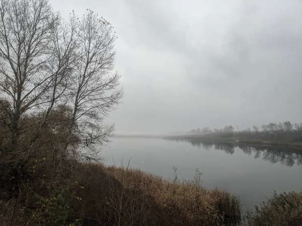 Autumn landscape with fog and water. gloomy landscape with fog. scary fog over the water.