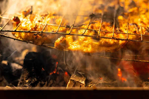 meat on fire. grilling. barbecue and chicken on the grill