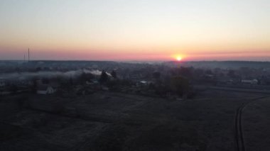 Şehrin üzerinde gün doğumu. Ufuktaki parlak kırmızı güneş. helikopter videosu