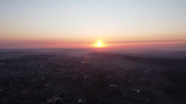 Şehrin üzerinde gün doğumu. Ufuktaki parlak kırmızı güneş. helikopter videosu