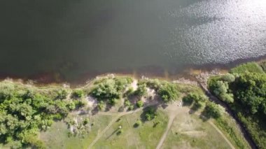 Yükseklerden nehrin olduğu güzel bir manzara. Yukarıdan kara ve nehir geliyor. Nehrin kıvrımları. Güneş, suya yansıyor. yeşil çimen ve toprak