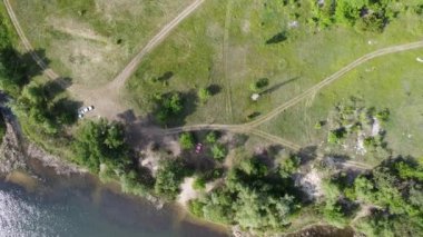 Yükseklerden nehrin olduğu güzel bir manzara. Yukarıdan kara ve nehir geliyor. Nehrin kıvrımları. Güneş, suya yansıyor. yeşil çimen ve toprak