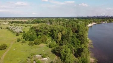 Yükseklerden nehrin olduğu güzel bir manzara. Yukarıdan kara ve nehir geliyor. Nehrin kıvrımları. Güneş, suya yansıyor. yeşil çimen ve toprak