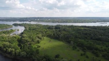 Yükseklerden nehrin olduğu güzel bir manzara. Yukarıdan kara ve nehir geliyor. Nehrin kıvrımları. Güneş, suya yansıyor. yeşil çimen ve toprak