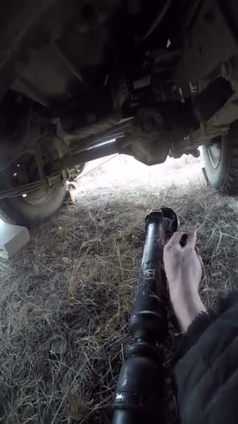 POV under bilman reparera propelleraxeln — Stockvideo