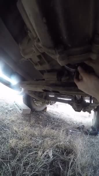 POV sous voiture homme réparation hélice arbre 
