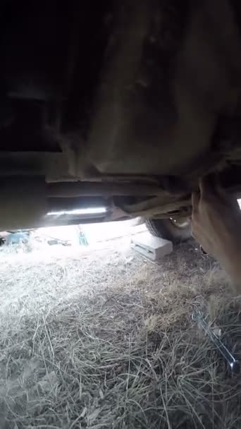 POV sob carro homem reparação hélice eixo — Vídeo de Stock