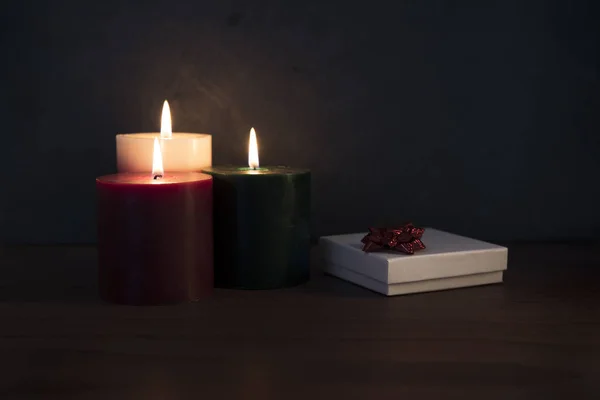 Tres velas y un regalo de Navidad —  Fotos de Stock