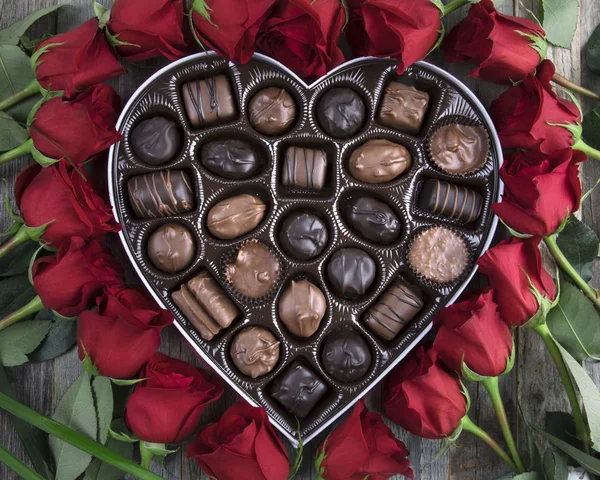 Caja de chocolates y rosas rojas —  Fotos de Stock