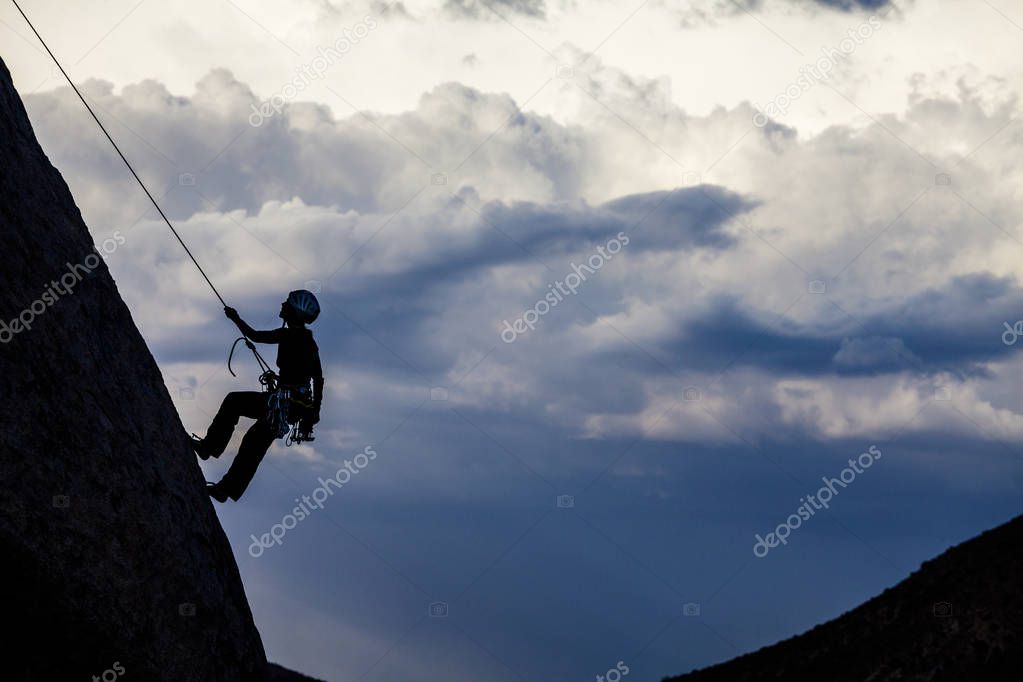 Rock climber rappelling.