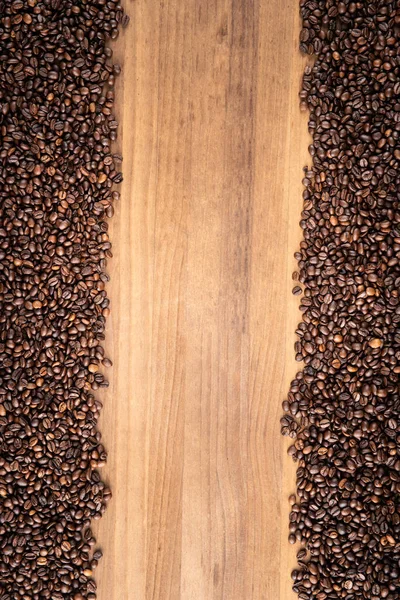 Frame made with coffee beans over wooden table