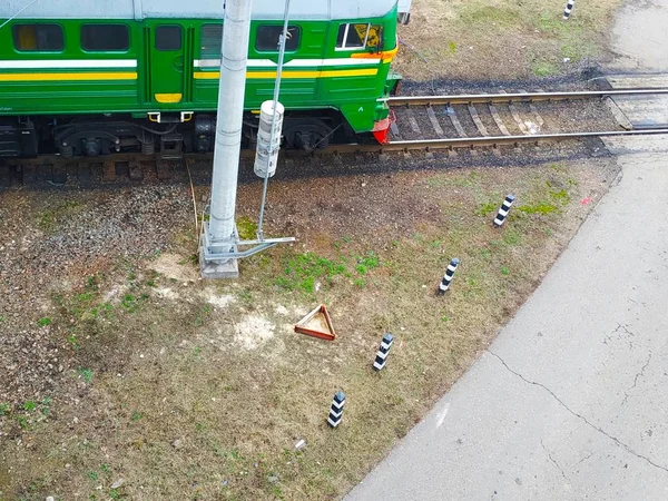 train travels on rails crossing a road