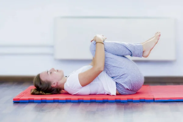 Jovem Realiza Exercício Com Joelhos Suas Costas — Fotografia de Stock