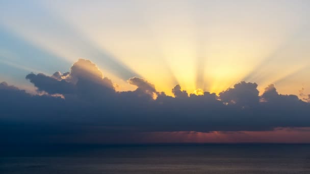 Timelapse promieni słonecznych pojawiających się chociaż chmury o wschodzie słońca nad morze. — Wideo stockowe
