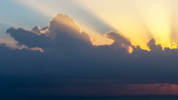 Timelapse promieni słonecznych pojawiających się chociaż chmury o wschodzie słońca nad morze. — Wideo stockowe