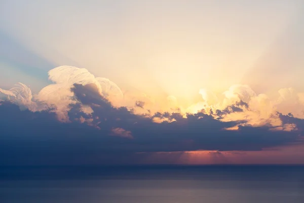 Ciel bleu avec nuages, mer et soleil à l'horizon — Photo