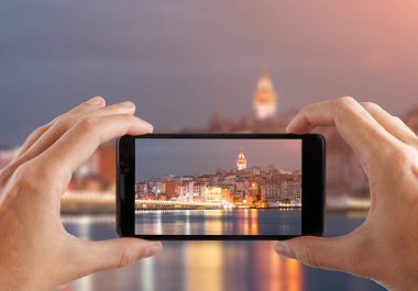 Seyahat kavramı. Eller smartphone kamerayla fotoğraf gece şehir yapma. Istanbul gün batımında. Türkiye