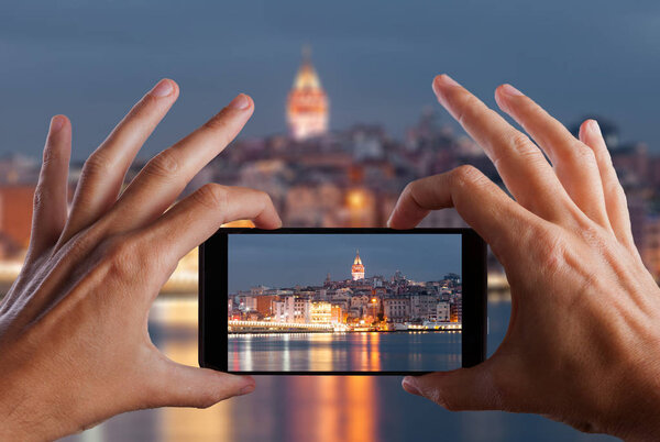 Travel concept. Hand making photo of city with smartphone camera. Istanbul. Turkey