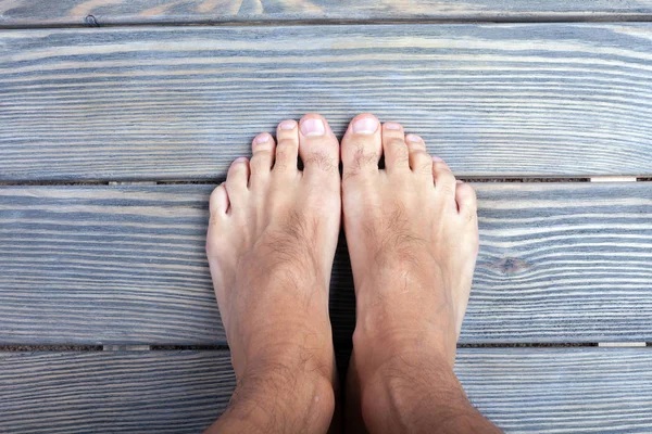 Male feet on wooden background. — Stock Photo, Image