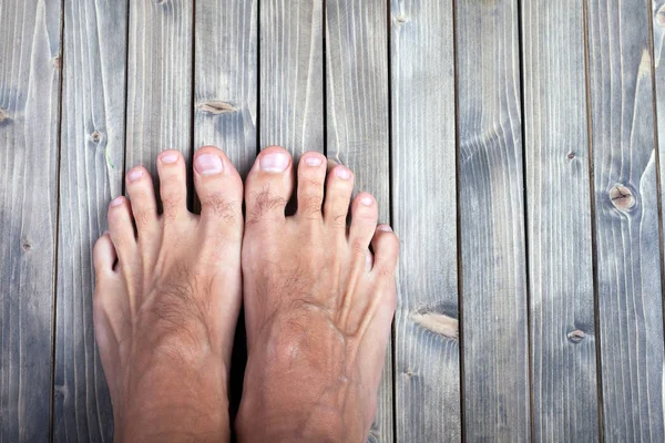 Male feet on wooden background. — Stock Photo, Image