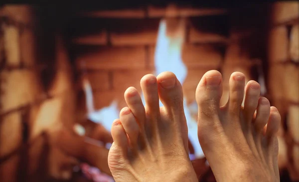 Naked legs are heated by a fireplace — Stock Photo, Image