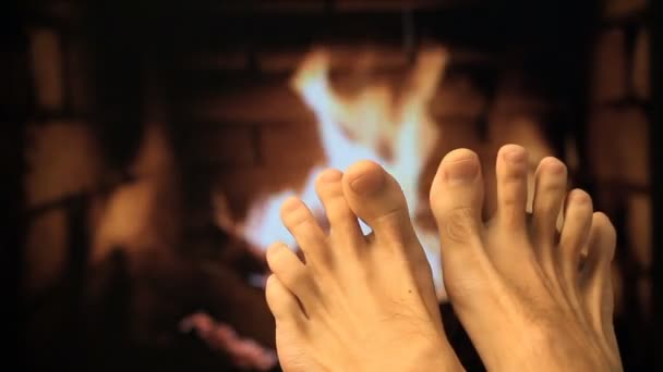 Naakte benen worden verwarmd door een open haard — Stockvideo