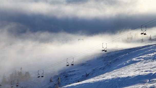 Montañas de invierno y remontes en un día nublado — Vídeo de stock