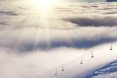 Kış karla kaplı dağlar, üzerine güneş.