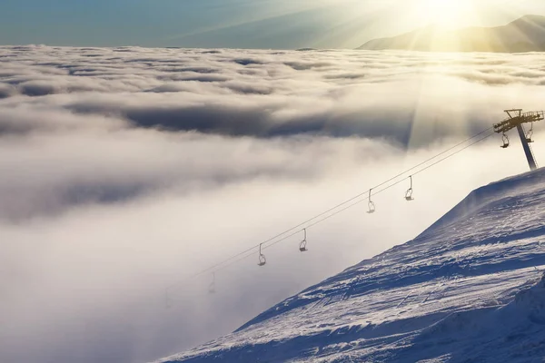 Sol sobre montañas de invierno, cubiertas de nieve . — Foto de Stock