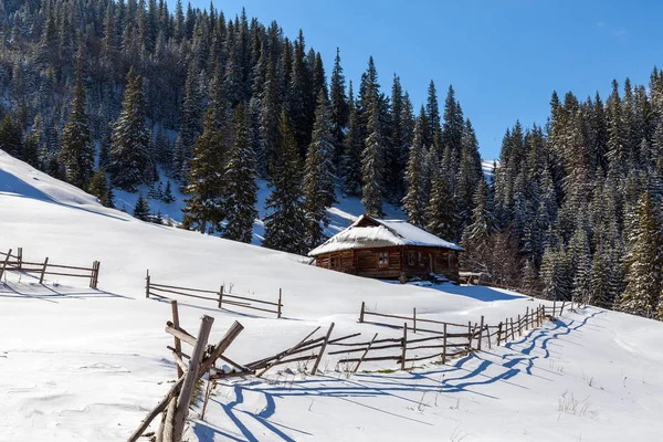 Casa de madera en un área natural cubierta de nieve recién caída . — Foto de Stock