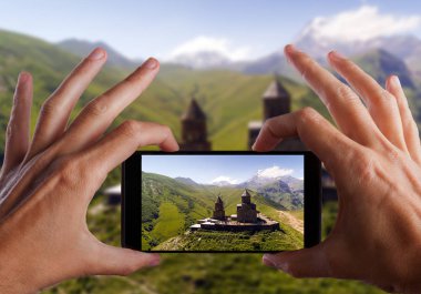 Seyahat kavramı. Eller fotoğraf Gergeti Manastırı yapma. Gürcistan. Europe