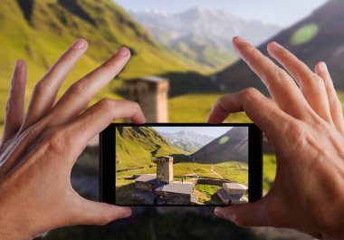 Seyahat kavramı. Eller fotoğraf Svaneti eski köyün Gürcistan'da yapma. Ortaçağ kule savunma amaçlı inşa.