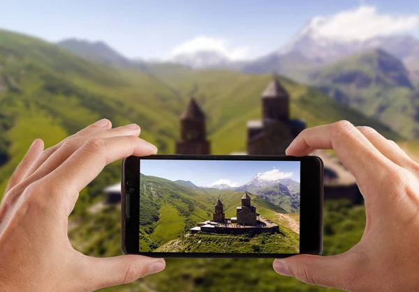 Seyahat kavramı. Eller fotoğraf Gergeti Manastırı yapma. Gürcistan. Europe