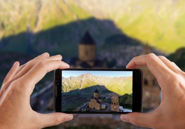 Seyahat kavramı. Eller fotoğraf Gergeti Ortodoks Kilisesi yüksek dağlar, Georgia yapma