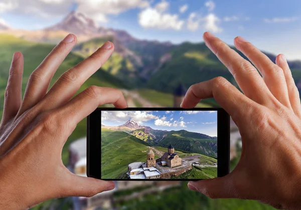 Seyahat kavramı. Eller fotoğraf Gergeti Ortodoks Kilisesi yüksek dağlar, Georgia yapma