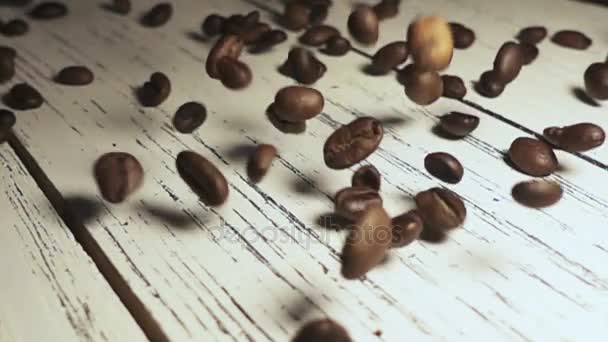 Granos de café tostados con polvo de café cayendo. Movimiento lento — Vídeo de stock