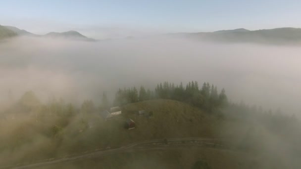 Vliegen door de mist over de dorpswoning in de bergen van Oekraïne — Stockvideo