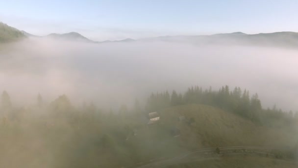 Voler à travers le brouillard au-dessus de la maison de village dans les montagnes de l'Ukraine — Video